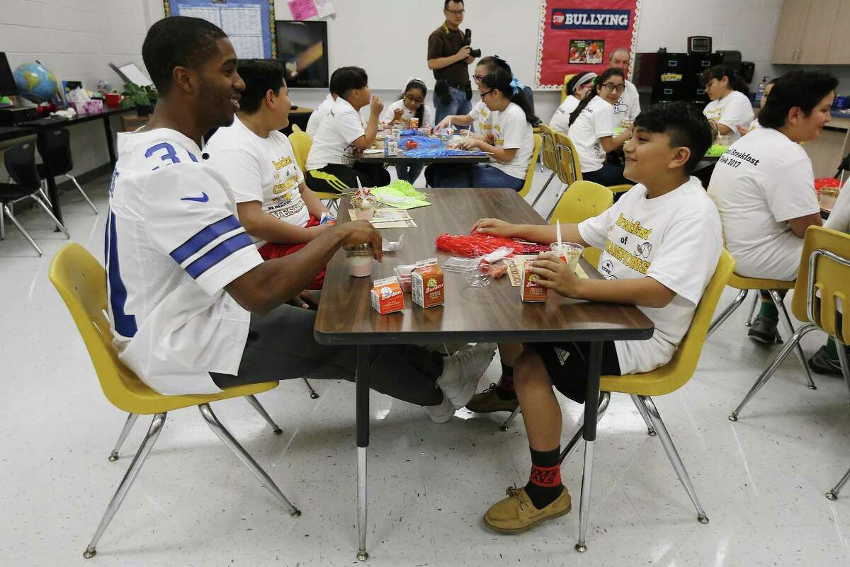 Dallas Cowboys safety Byron Jones chats with fifth-grade student Ernesto Estrada (right) at Vestal Elementary for an event to promote eating right and staying active on Thursday, Mar. 9, 2017. The nonprofit Dairy Max sponsored the event in partnership with the National Football League and U.S. Department of Agriculture. The students competed in an obstacle course challenge, with one of three teams coached by Jones, and learned from a local dairy farmer. (Kin Man Hui/San Antonio Express-News)