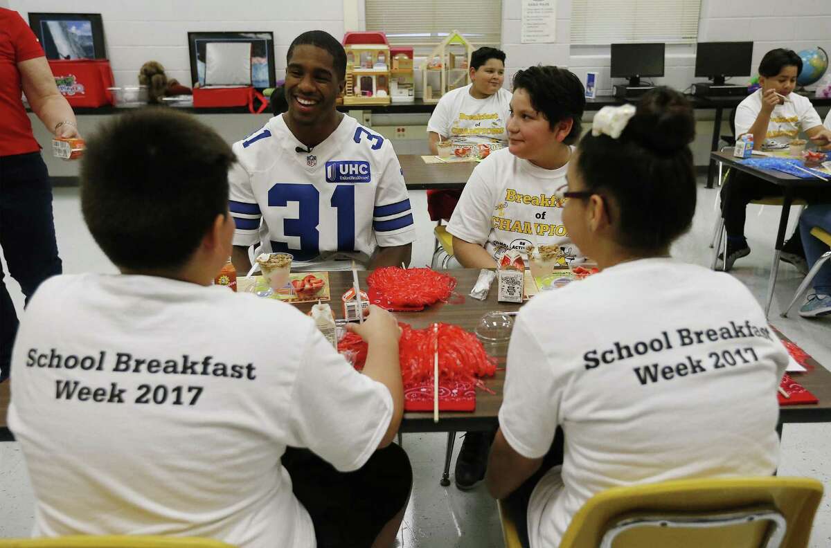 Dallas Cowboys safety Byron Jones (31) sits down and chats with Vestal Elementary students for an event to promote the consumption of dairy products toward a healthier lifestyle on Thursday, Mar. 9, 2017. The students competed in an obstacle course challenge with Jones coaching one of three teams. They also learned from a local dairy farmer. (Kin Man Hui/San Antonio Express-News)
