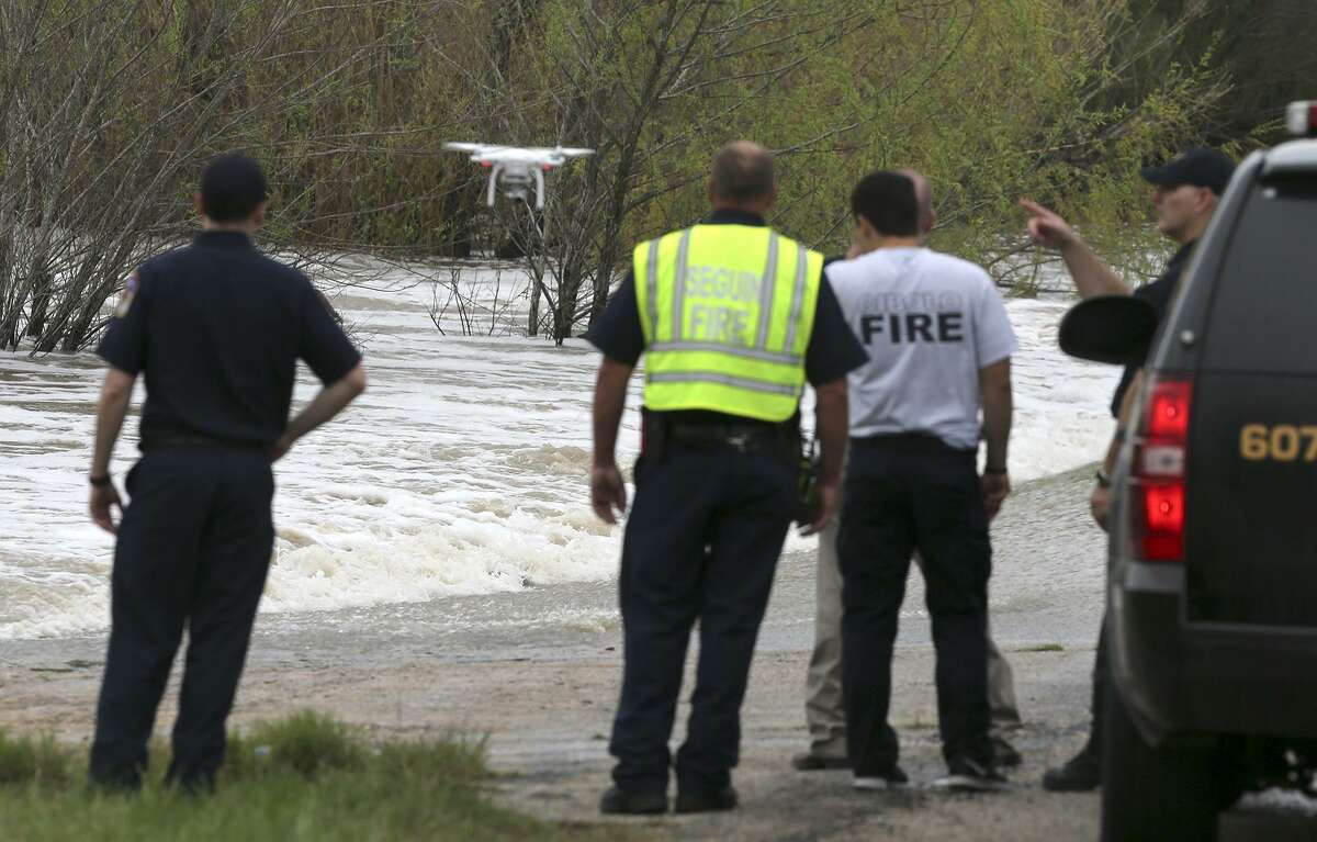 Officials search floodwaters after a car was swept away in Santa Clara Creek south of Marion. A woman’s body was later found.