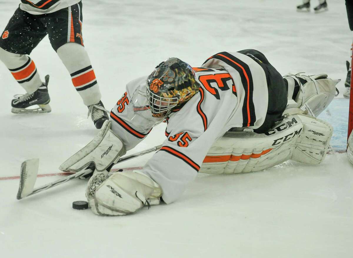 Ridgefield goalie Sean Keegans dives for the puck for one of his 39 saves Saturday agianst Fairfield Prep.