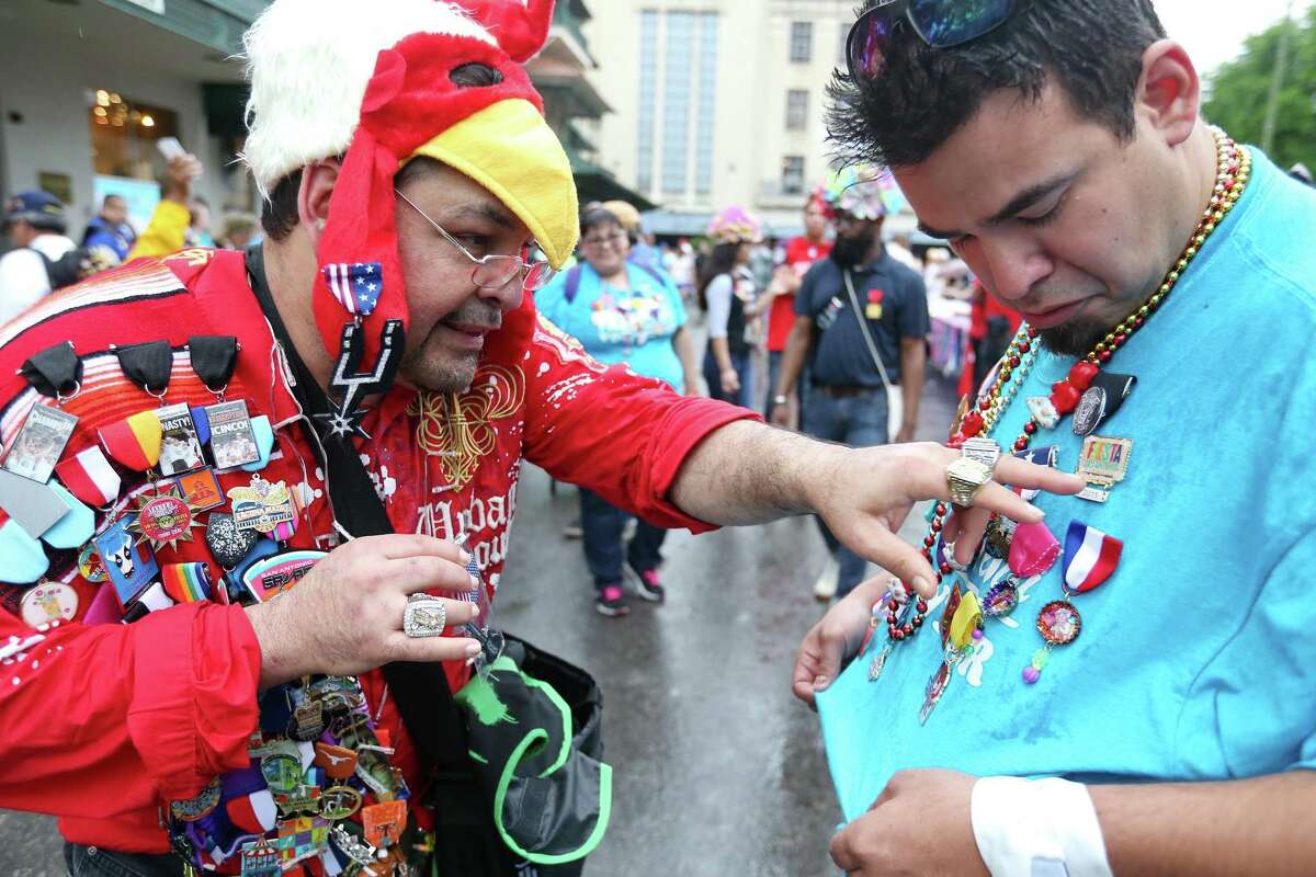 Paul Gonzales (left) and Adam Rocha trade Fiesta medals at Pin Pandemonium part of the Fiesta Fiesta at the Alamo event, the official opening of Fiesta Thursday April, 16, 2015.