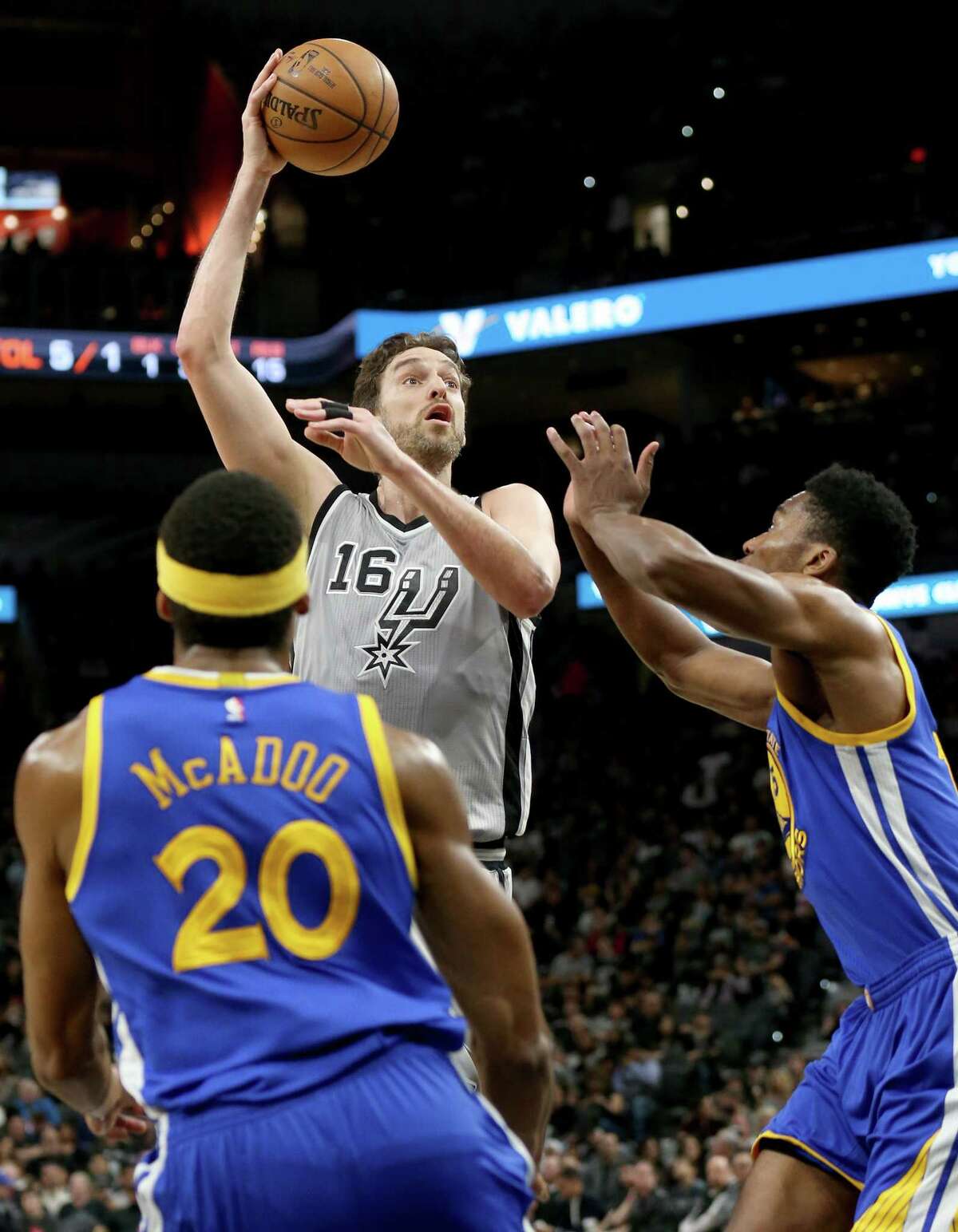 San Antonio Spurs' Pau Gasol shoots between Golden State Warriors' James Michael McAdoo (left) and Damian Jones during first half action Saturday March 11, 2017 at the AT&T Center.