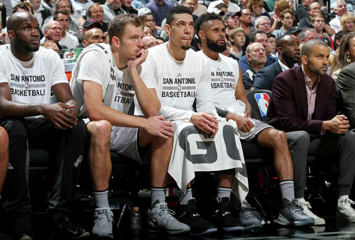 Spurs players watch first-half action against Golden State on March 11.