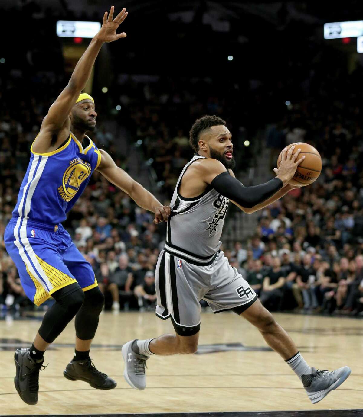 San Antonio Spurs' Patty Mills looks for room around Golden State Warriors' Ian Clark during first half action Saturday March 11, 2017 at the AT&T Center.