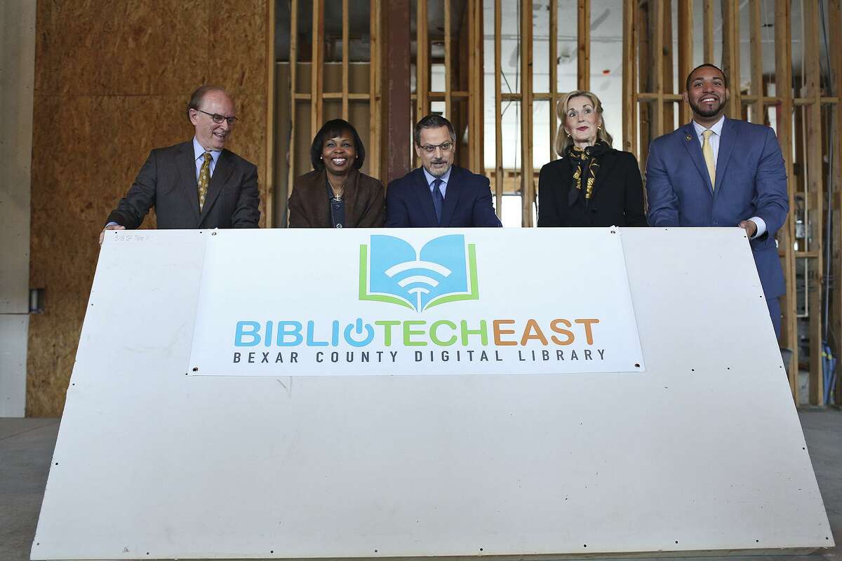 Bexar County Judge Nelson Wolff, San Antonio Mayor Ivy Taylor, San Antonio Housing Authority President and CEO David Nisivoccia, Tracy Wolff and County Commissioner Tommy Calvert lift a ceremonial wall during an event at the new BiblioTech digital library under construction on the East Side. The facility is scheduled to open in August.