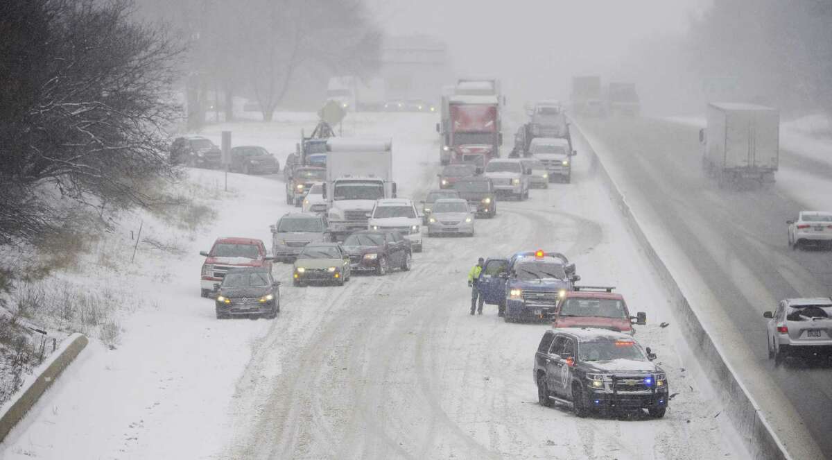 Blackman-Leoni Department of Public Safety officers and other rescue personnel work at the scene of a crash involving a semi trailer under the Cooper Street bridge of Interstate 94 westbound on Monday, March 13, 2017, in Jackson, Mich. Most of Michigan is getting snow as utility crews work to restore electrical service to thousands of customers still without power following last week's high winds. (J. Scott Park/Jackson Citizen Patriot via AP)