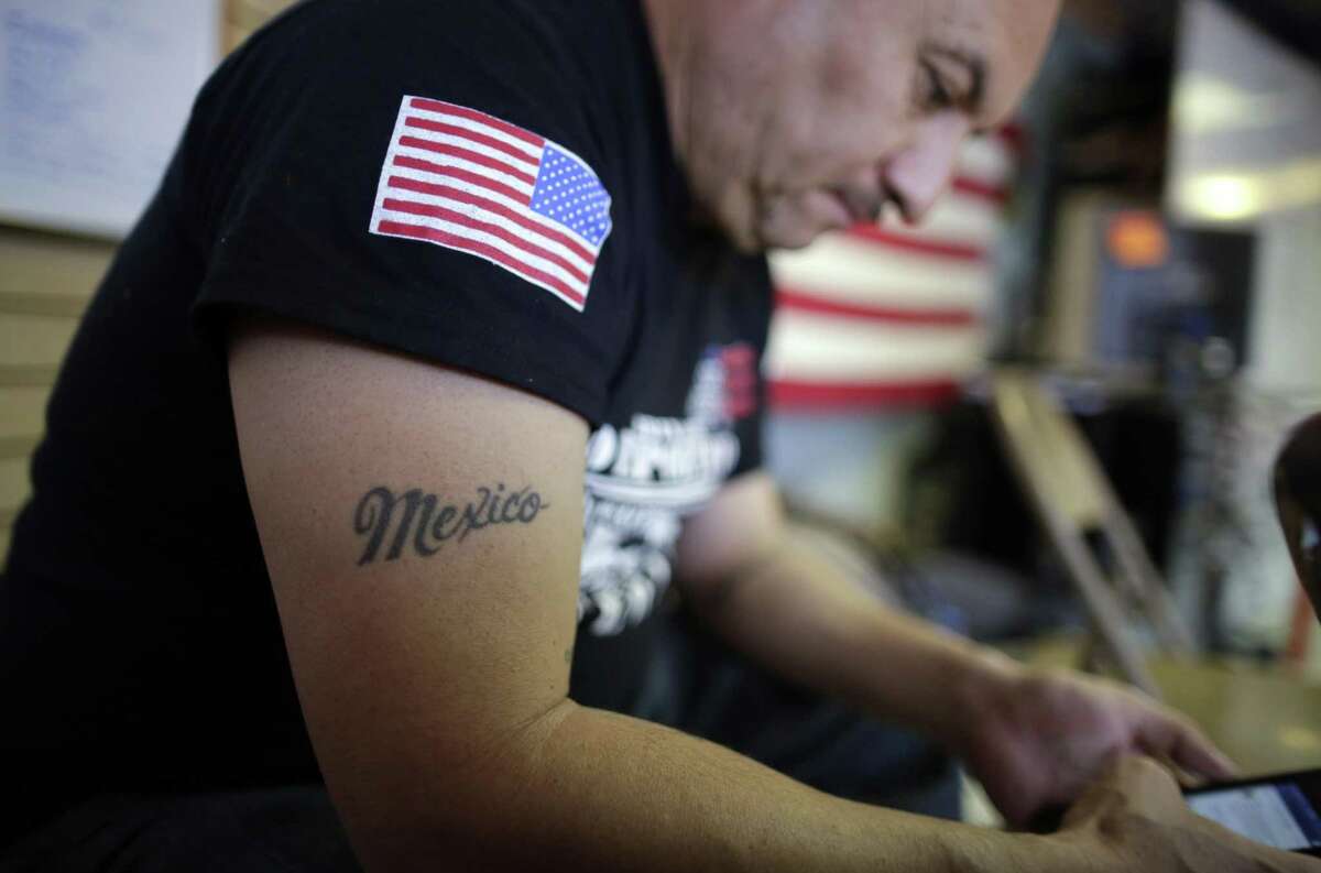 This Feb. 13, 2017 photo shows the tattoo on the right arm of U.S. veteran Hector Barajas, who was deported, as he sits in his office at the Deported Veterans Support House, nicknamed "the bunker" in Tijuana, Mexico. Barajas, a former paratrooper who was born in Zacatecas state, crossed illegally into the United States at age 7 and served in the Army from 1995 to 2001. (AP Photo/Gregory Bull)