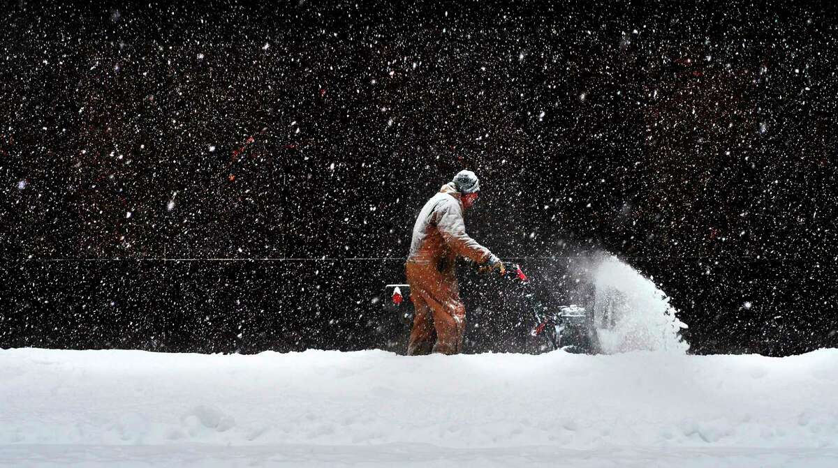 Jo Lewis with Douglas R. Dyer Contracting out of Mechanicville clears snow off the sidewalk outside the Verizon building as more snow falls on Tuesday, March 14, 2017, in Troy, N.Y. (Paul Buckowski / Times Union)