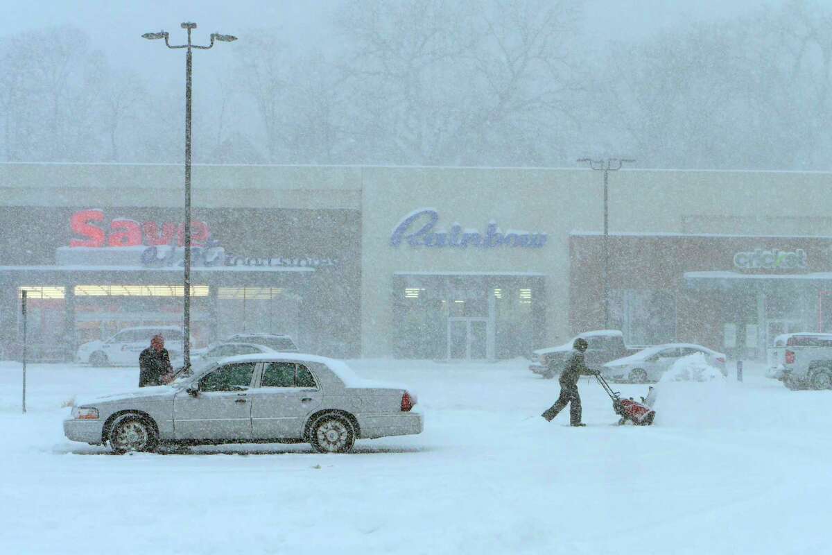 People clear snow, off cars and the parking lot at Hudson River Commons on Tuesday, March 14, 2017, in Troy, N.Y. (Paul Buckowski / Times Union)