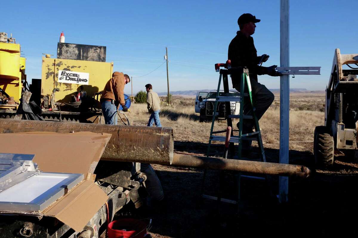 Scientists from the University of Texas and a contractor, Nanometrics, install a seismometer on a hillside owned by Sul Ross University in Alpine.