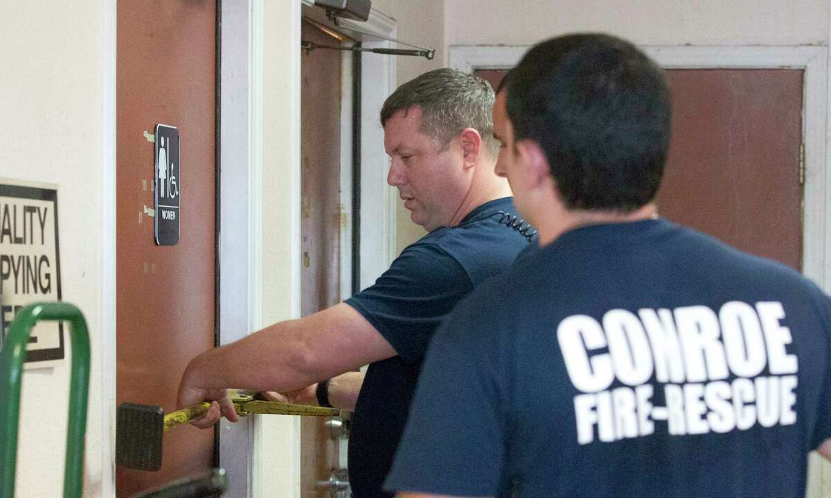 Firefighters with the Conroe Fire Department work to free Conroe City Council member Duane Ham after he accidently locked himself in a unisex bathroom at Super Z Food Market on Tuesday, March 14, 2017, in Conroe.