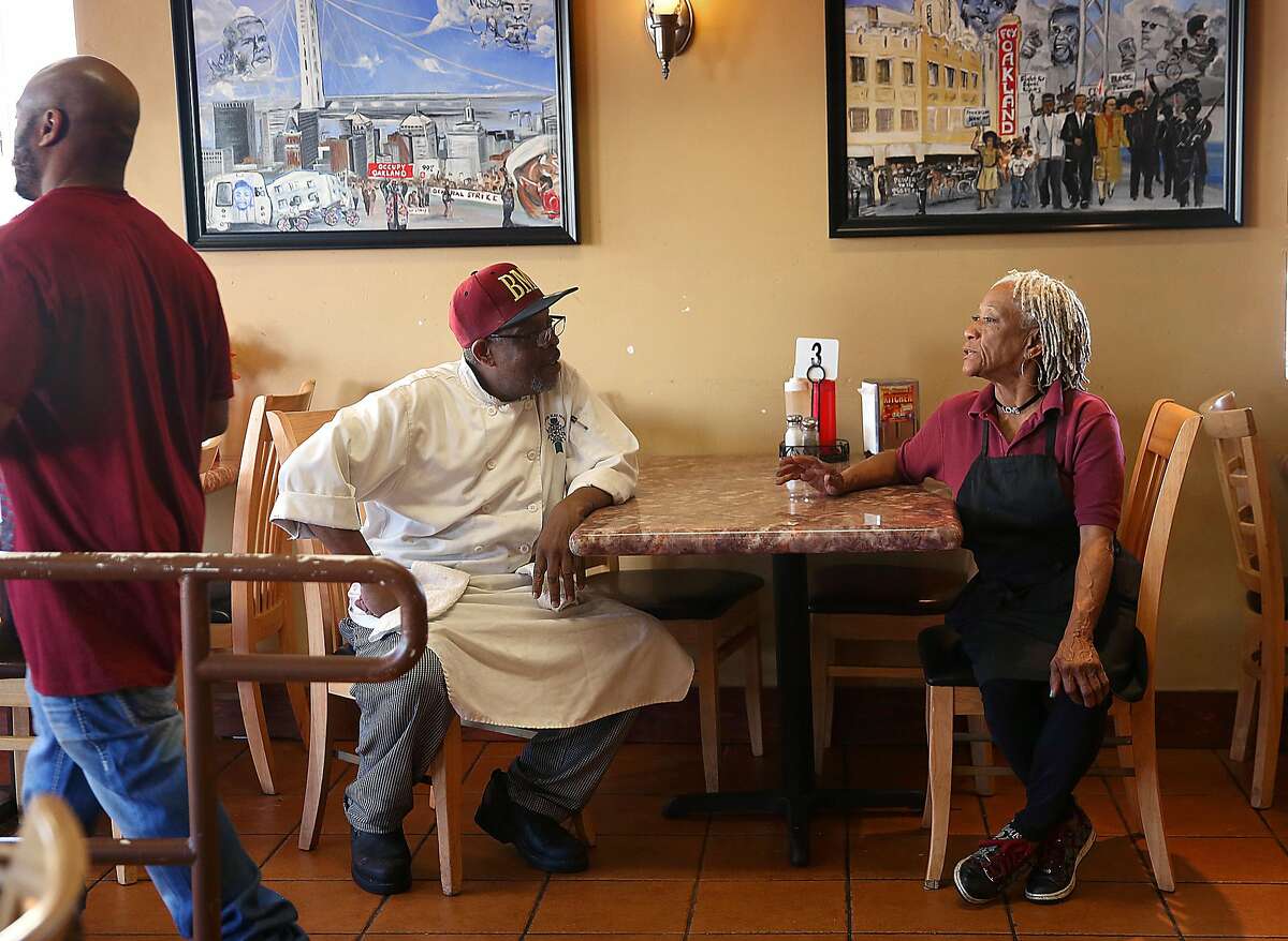 Head cook Rico Calhoun (left) talks with Bella Coffey (right) at Big Momma's Kitchen on Tuesday, March 14, 2017, in Oakland, Calif. At left is Bella's son Tyreke Coffey.