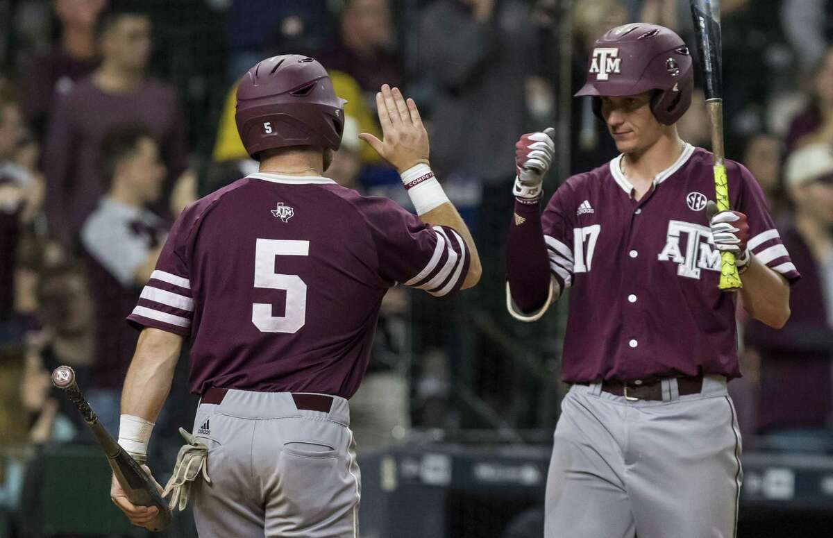 Texas A&M’s Logan Foster (5) and Joel Davis celebrate after Foster scored against Baylor at Minute Maid Park in March 5, 2017, in Houston.