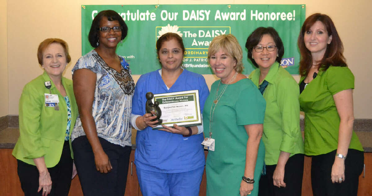 DAISY Award Recipient, Lee Cantos, RN, with her children and the DAISY Award Committee