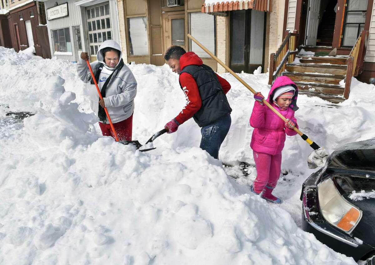 Tracy Giggette, left, and children Tyrese Sturdavant, 13, and Talani Giggette, 6, right, dig their car out of a snow bank on Lexington Avenue after yesterday's blizzard Wednesday March 15, 2017 in Albany, NY. (John Carl D'Annibale / Times Union)
