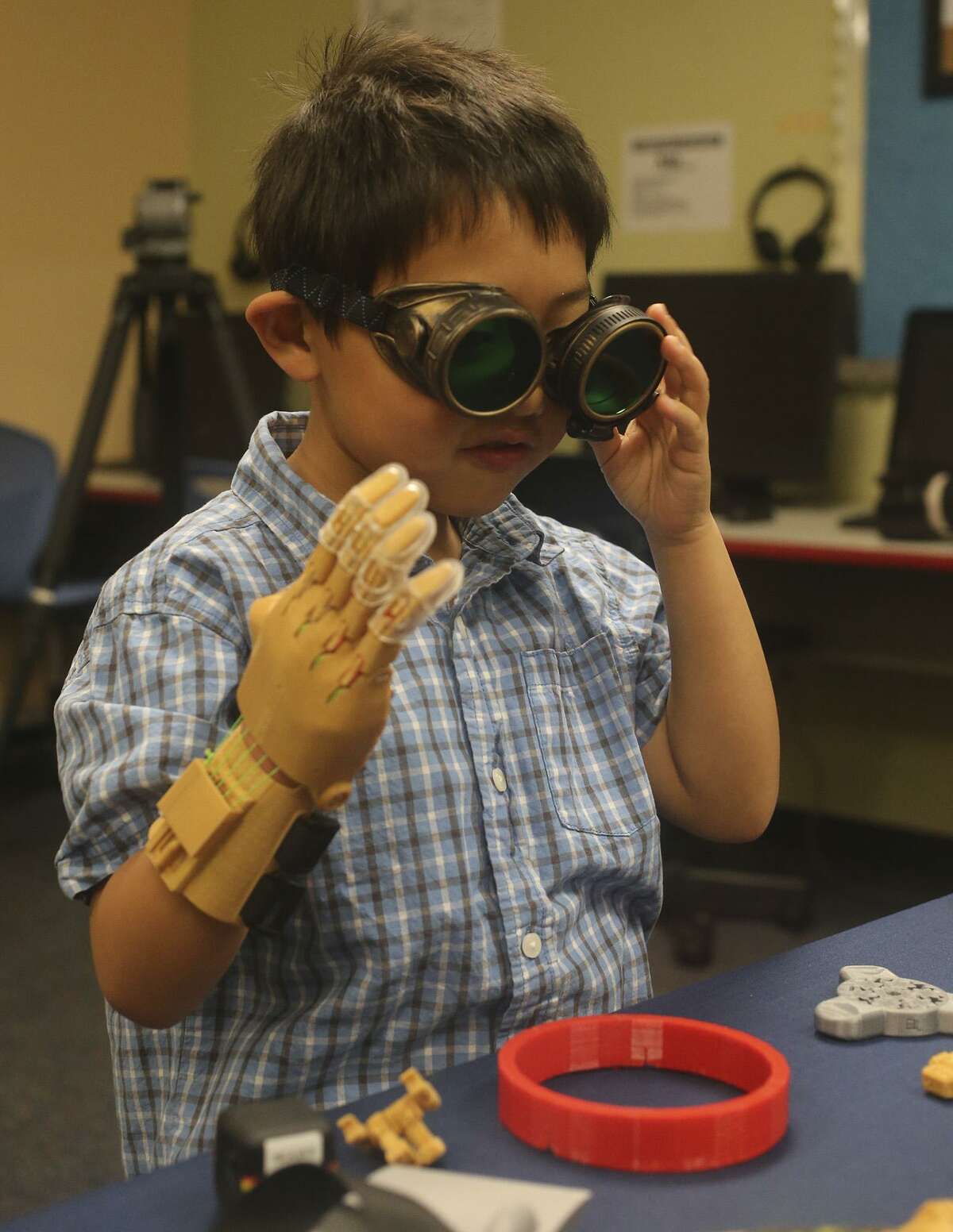 Zack Robbins,6, uses a prosthetic hand Wednesday March 8, 2017 made with a 3D printer by School of Science and Technology student Justin Cantu,16. Robbins was born with underdeveloped right hand and Cantu used technology created by an on-line community called e-NABLE to make the hand for Robbins.