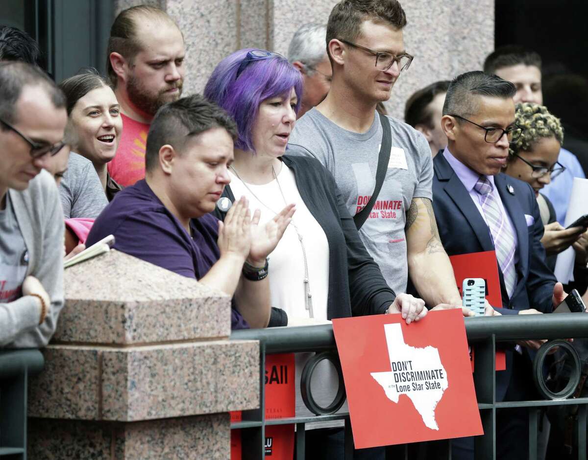 Ginger Chun (center) holds her sign in a rally in the outdoor area of the Capitol extension as the Senate State Affairs committee holds a hearing on the controversial bathroom bill,bill SB6, in the Capitol on March 7, 2017.