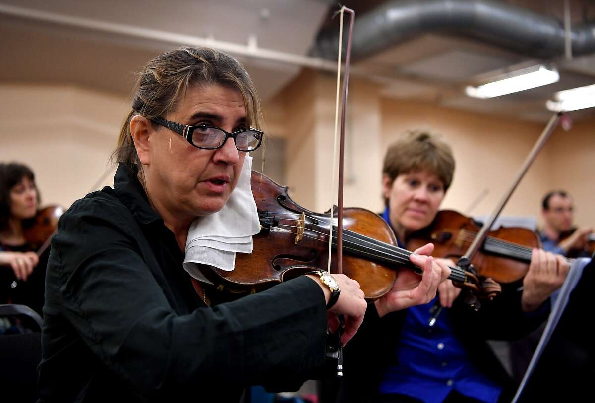 Violinist Nadja Salerno-Sonnenberg (L) plays violin while also directing the New Century Chamber Orchestra during a rehearsal at Zellerbach Hall in San Francisco on March 15, 2017.