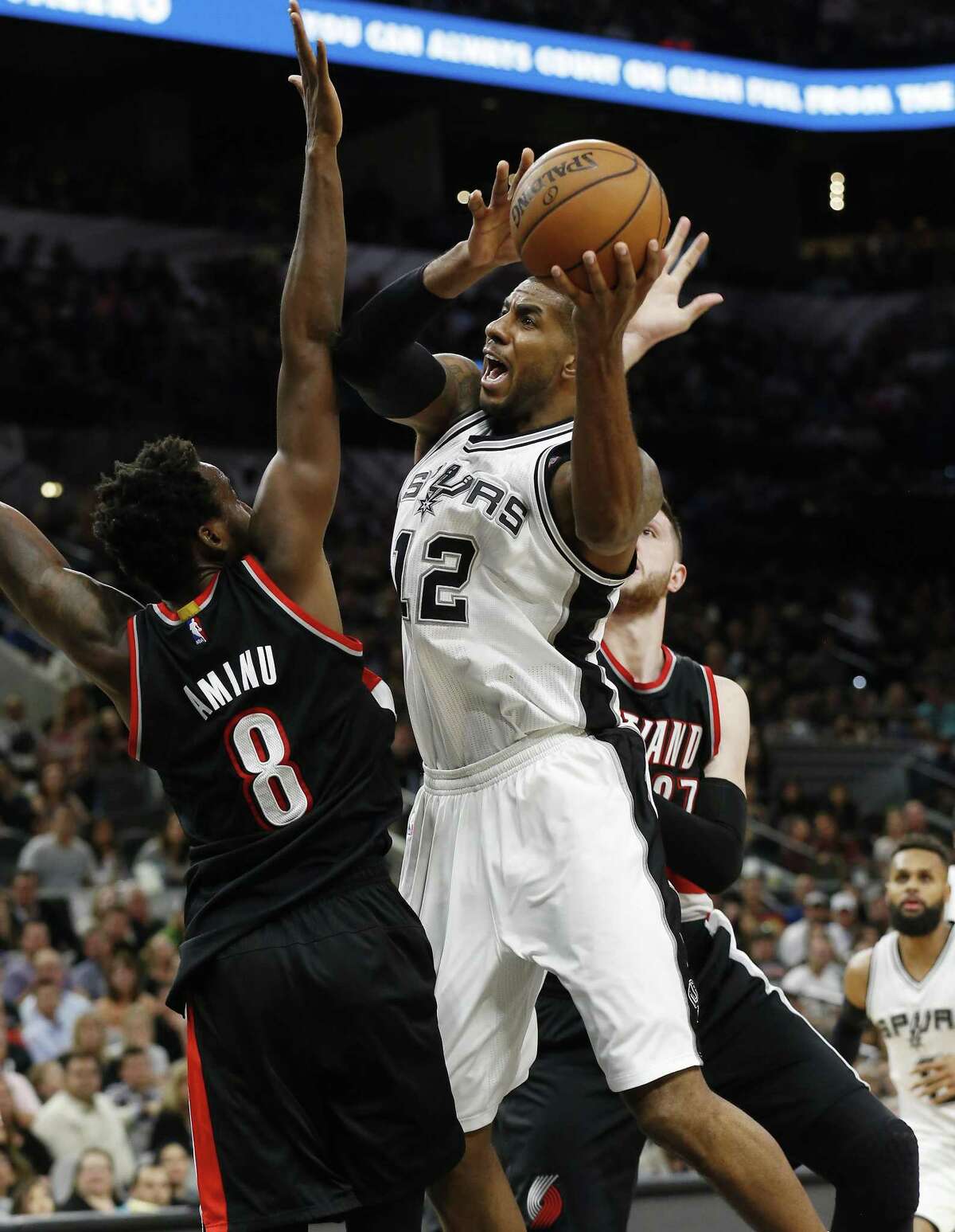 Spurs’ LaMarcus Aldridge (center) gets challenged on a shot by the Portland Trail Blazers’ Al-Farouq Aminu (left) and Jusuf Nurkic (right) at the AT&T Center on March 15, 2017.