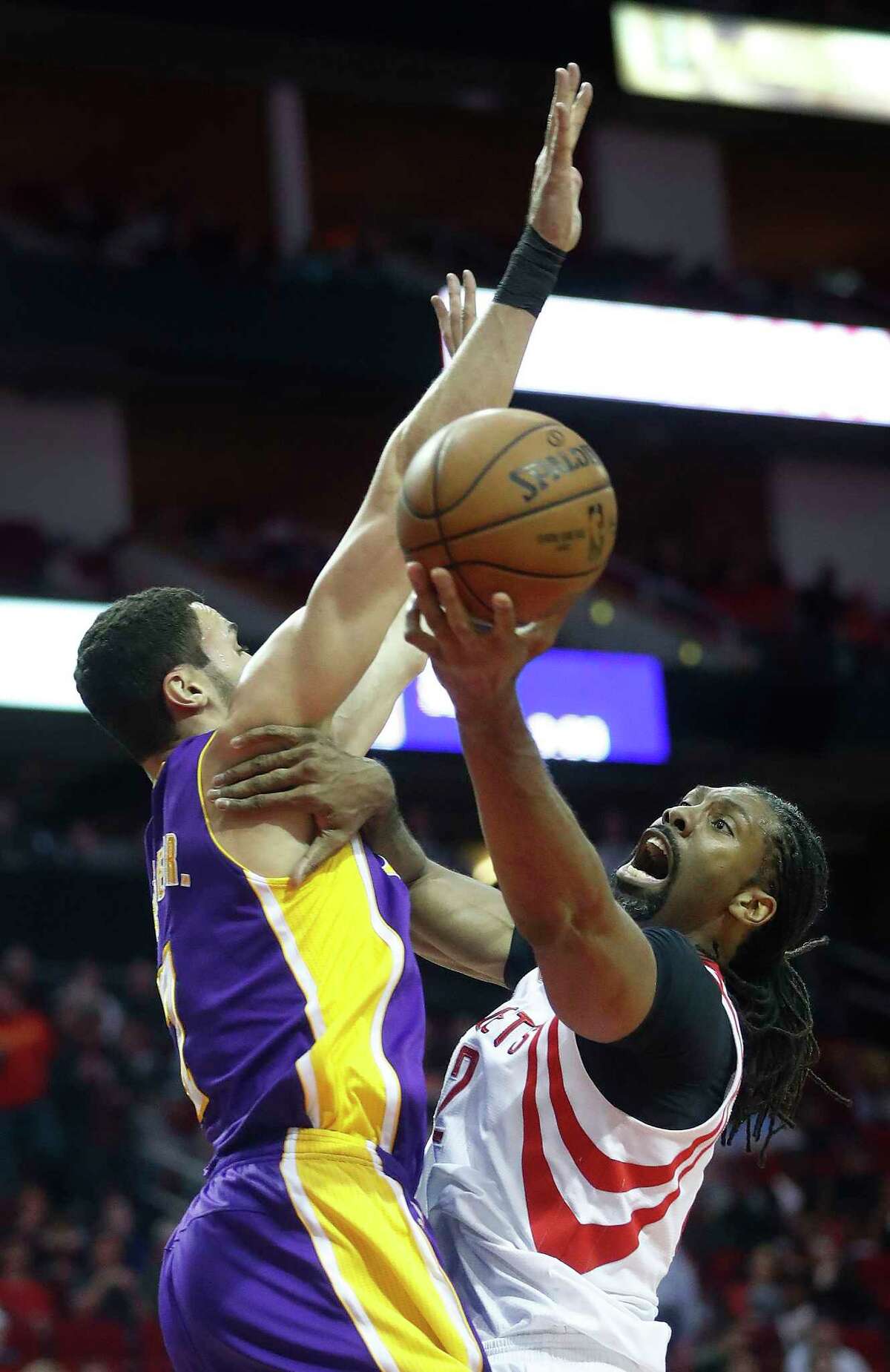 Rockets center Nene, right, tries to find a way to score around the Lakers' Larry Nance.
