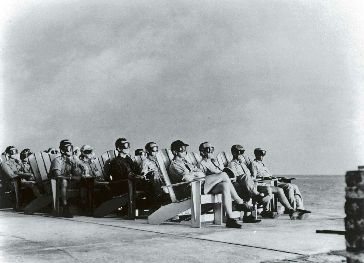 High ranking military personnel sitting in rows of deck chairs & wearing goggles while getting illuminated by flare of atomic detonation at Atomic Energy Commission's Pacific Proving Ground during Operation Greenhouse. (Photo by Time Life Pictures/Us Air Force/The LIFE Picture Collection/Getty Images)