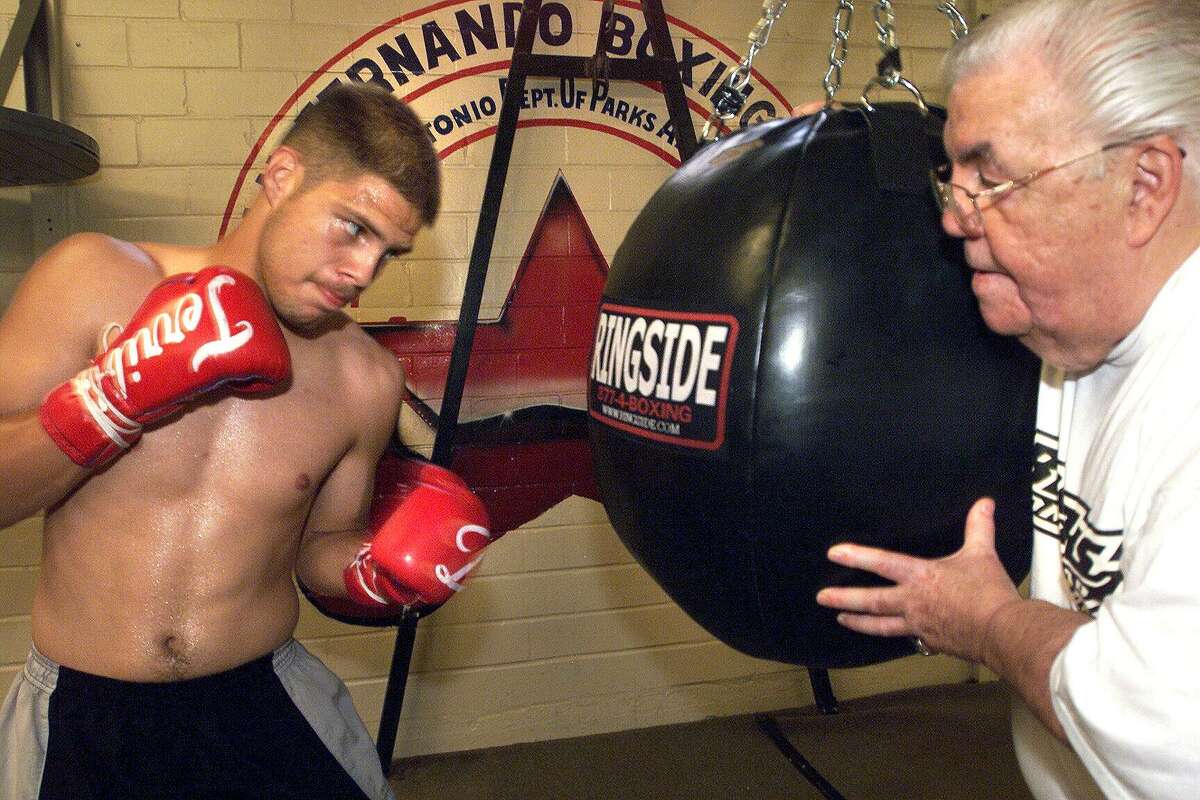 Omar Davila works out on the big bag at San Fernando Gym on Aug. 3, 2001, with manager/trainer Lou Duva assisting.