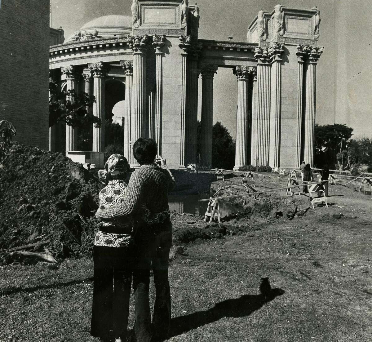 Caption on the back of the photo: "Two young folks in love view the Palace of Fine Arts and the reconstruction area." September 17. 1973