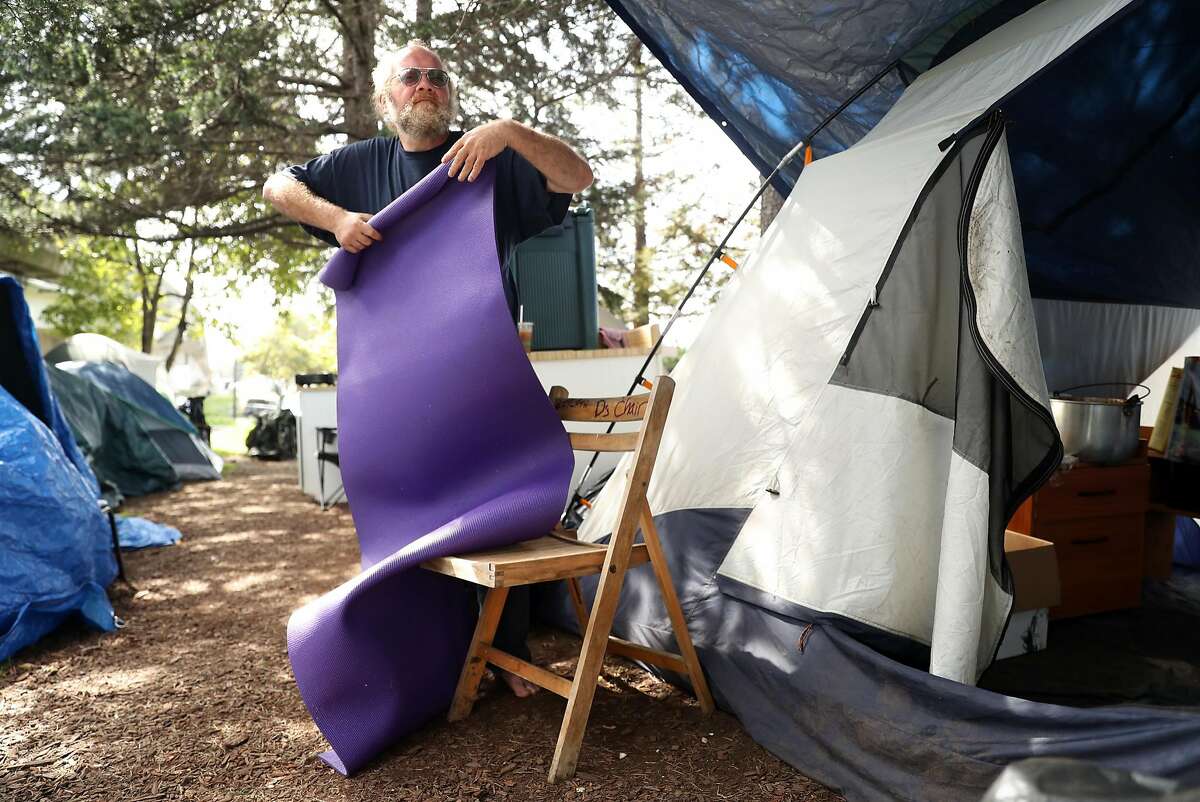 Brett Schnaper cleans up his campsite at a homeless encampment on Martin Luther King, Jr. Way at Adeline Street in Berkeley, Calif., on Thursday, March 16, 2017.