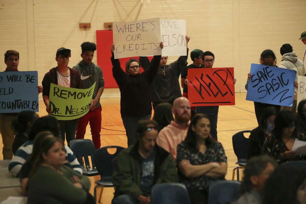 Students hold signs as parents and students express their concerns before two board members of the San Antonio School for Inquiry & Creativity, (SASIC), at their Preparatory Academy campus on Fredericksburg Road, Wednesday, Feb. 15, 2017. Tensions are bubbling over at SASIC, a small charter district beset by an array of complaints of corruption, mismanagement and negligence. Students and parents accuse the district of a range of offenses, including serving spoiled food to students, not providing toilet paper and soap in the bathrooms, and not paying employees, among many others. On Wednesday, parents and community members expressed their grievances at an open forum before board president Denise Fritter and member Nathan Wiegreffe.