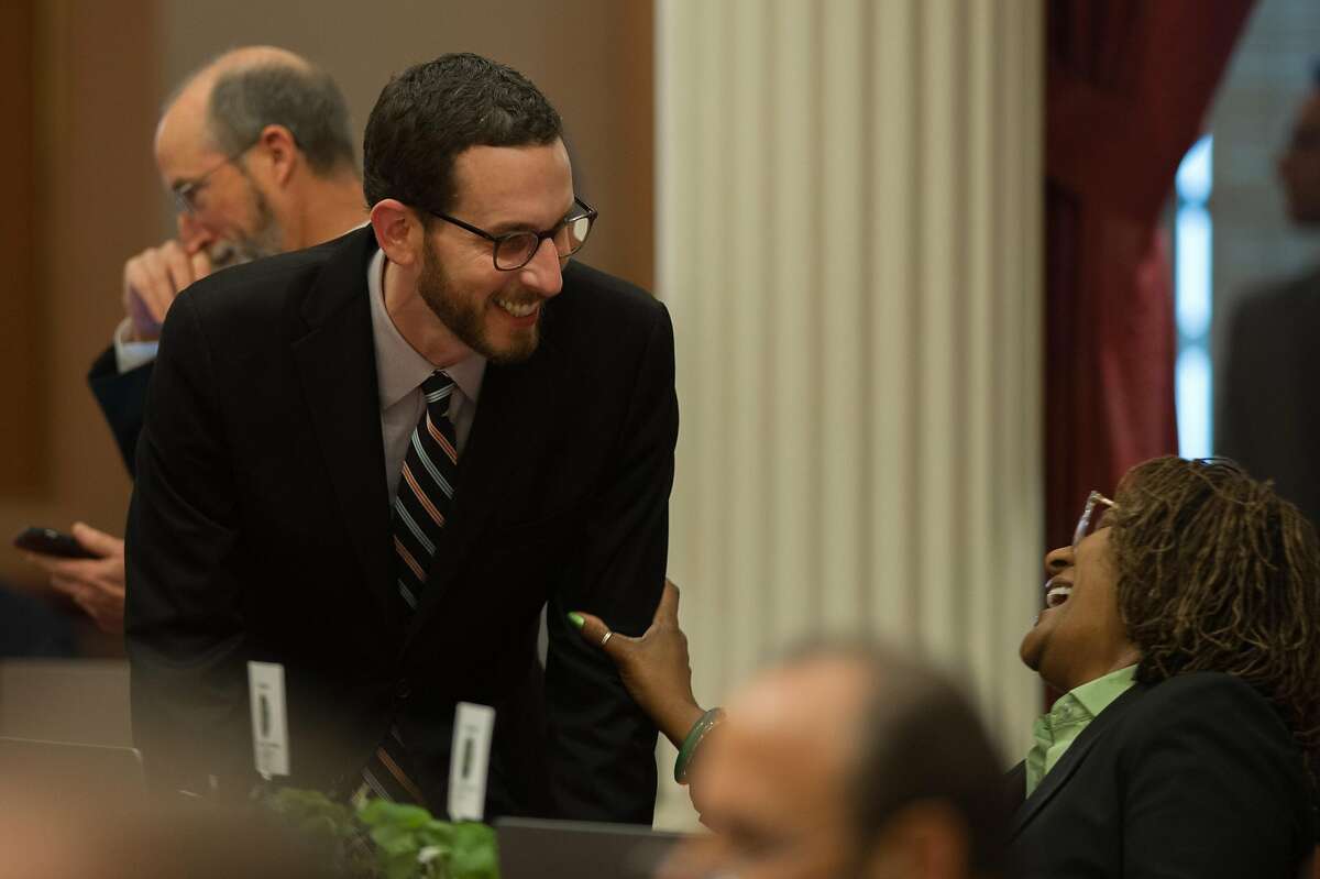 Sen. Scott Wiener, D-San Francisco, left, talks with Sen. Holly Mitchell, D-Los Angeles, on the Senate floor in the state Capitol in Sacramento, Calif. on Thursday, March 16, 2017.