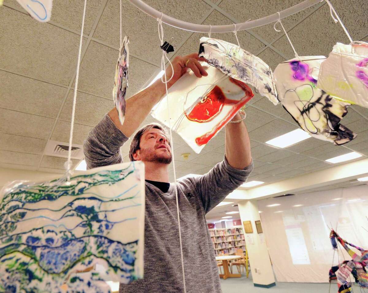 Art teacher Michael Manning installs a stained-glass artwork done by his North Mianus School students that was on display as part of the Greenwich Public Schools K-12 District Art Show at the media center in Greenwich High School, Conn., Thursday, March 16, 2017. The show runs until March 29th and features artwork from students in all the Greenwich Public Schools.