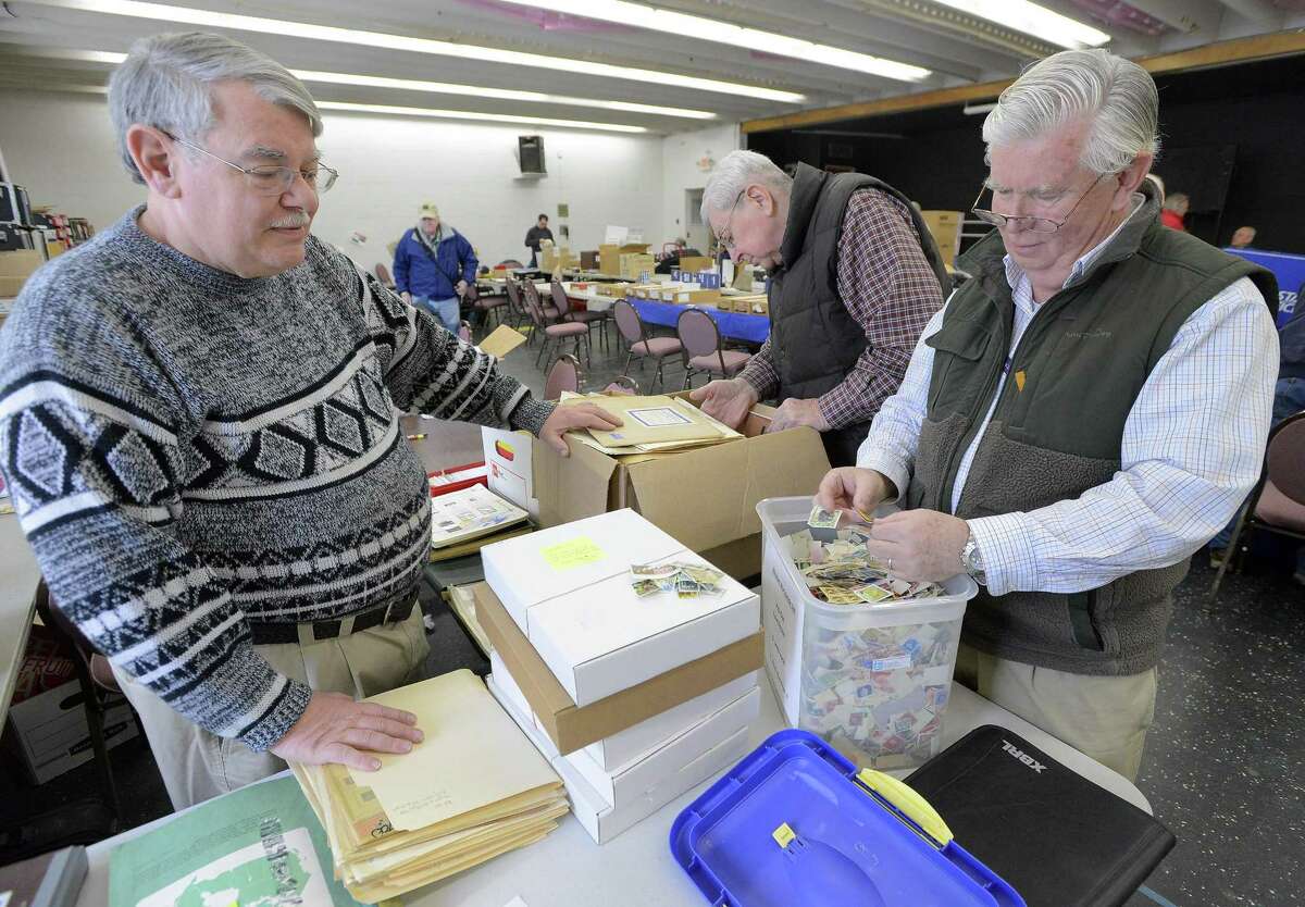 Stamp dealer and Norwalk Stamp Club member Dave Dauplaise of Stamford, at left, helps Bill Armstrong of Westport, at right, as he sorts through some 50,000 loose stamps for his various collections. The Norwalk Philatelic Exhibition (known as NORPEX), the longest running stamp show in the region, took place March 11 at the Norwalk Senior Center. A dozen stamp dealers with a global inventory of more than 750,000 stamps and other philatelic material set up booths to serve the needs of area collectors. The U.S. Postal Service was on hand offering current commemorative stamps and the Norwalk Stamp Club offered a special commemorative cachet designed by famed illustrator Chris Calle that included a new stamp issued Feb. 20 by the U.S. Postal Service honoring President John F. Kennedy.