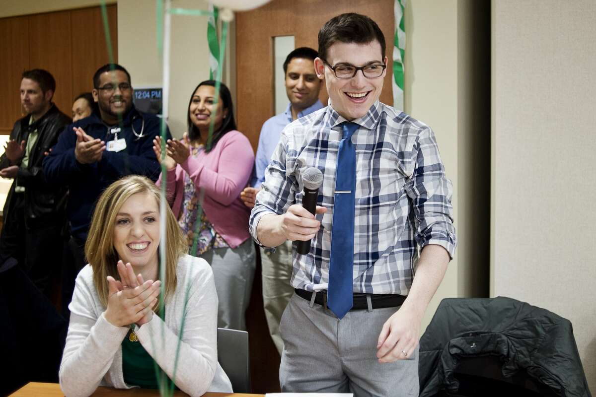 Fourth-year Michigan State University College of Human Medicine student Dan Drake, right, and wife Christine Drake, left, celebrate Dan's placement at MidMichigan Medical Center - Midland for a residency program in family medicine during Match Day at the MidMichigan Medical Center Gerstacker Building on Friday. Ten students opened envelopes to find out where they had been matched for a residency program whether in Michigan or across the country.