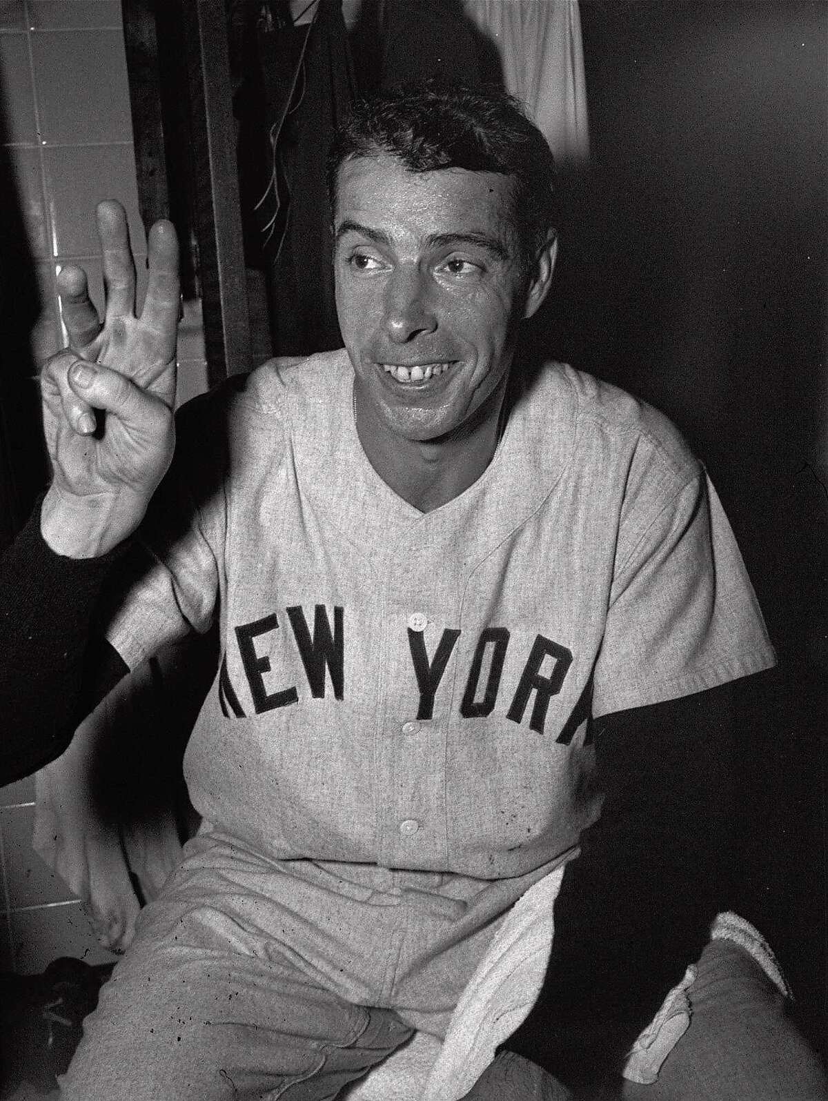 FILE -- Joe DiMaggio grins in the New York Yankees' dressing room as he holds up three fingers to denote the three home runs he hit as the Yanks defeated the Washington Senators 8-1 in the first game of a doubleheader at Washington, in this September 10, 1950 photo. DiMaggio's fight for life has turned more urgent with his doctor reporting Monday Dec. 7, 1998 that the Hall of Famer's condition had deteriorated dramatically. (AP Photo/ File )