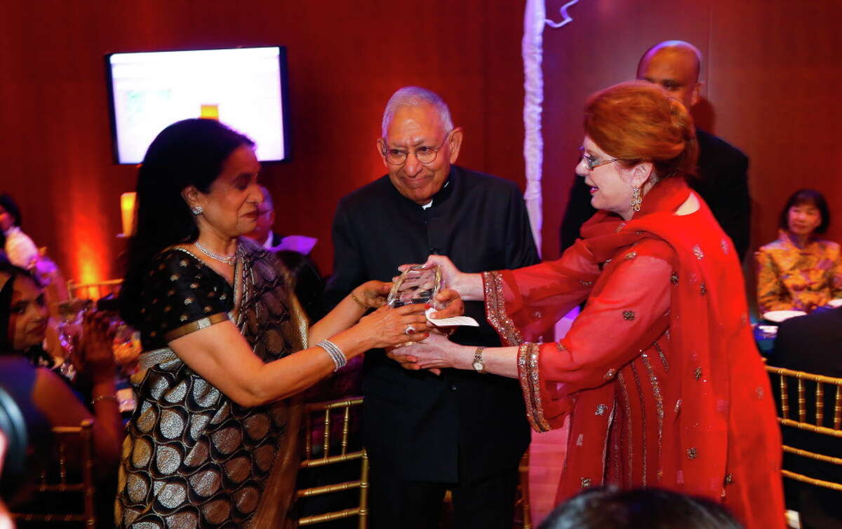 Tiger Ball honorees Sushila and Dr. Durga Agrawal receive a trophy from Joni Baird at the Asia Society's Tiger Ball.﻿