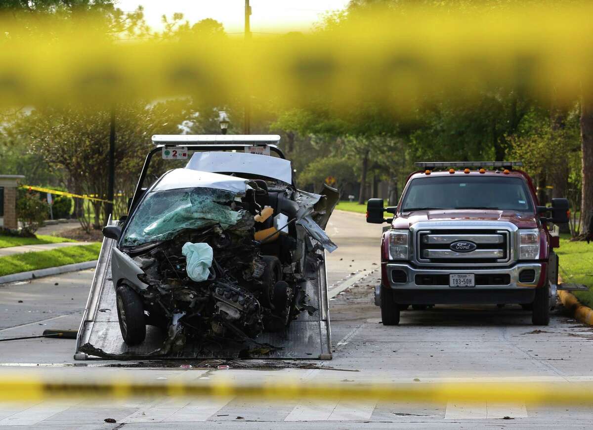 The wrecked silver Honda Civic that was involved in a police chasing is being towed away at the intersection of Kingsland Boulevard and Goughton Drive Sunday, March 12, in Katy. The driver died in the car. ( Yi-Chin Lee / Houston Chronicle)
