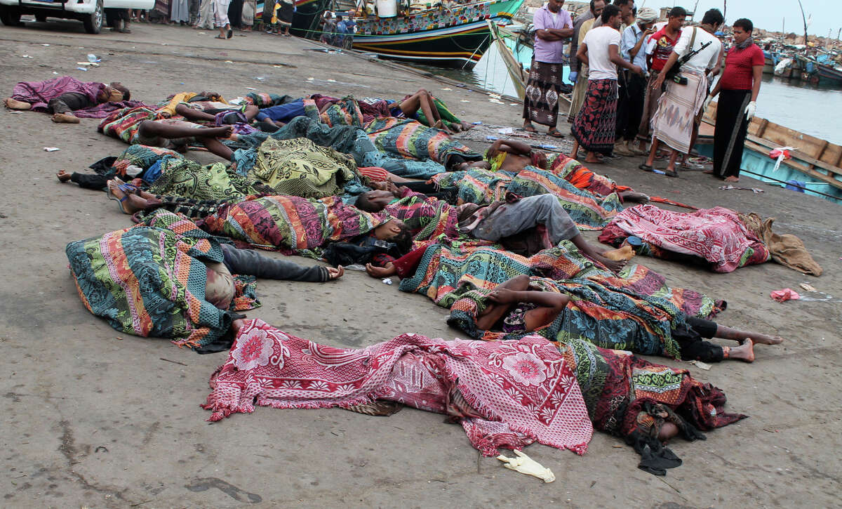 Bodies of Somali migrants, killed in attack by a helicopter while traveling in a boat off the coast of Yemen, lie on the ground at Hodeida city, Yemen, Friday, Mar. 17, 2017. A helicopter gunship attacked a boat packed with Somali migrants off the coast of Yemen overnight Thursday, killing at least 31 people, according to a U.N. agency, Yemeni officials and a survivor who witnessed the attack. (AP Photo/Abdel-Karim Muhammed)