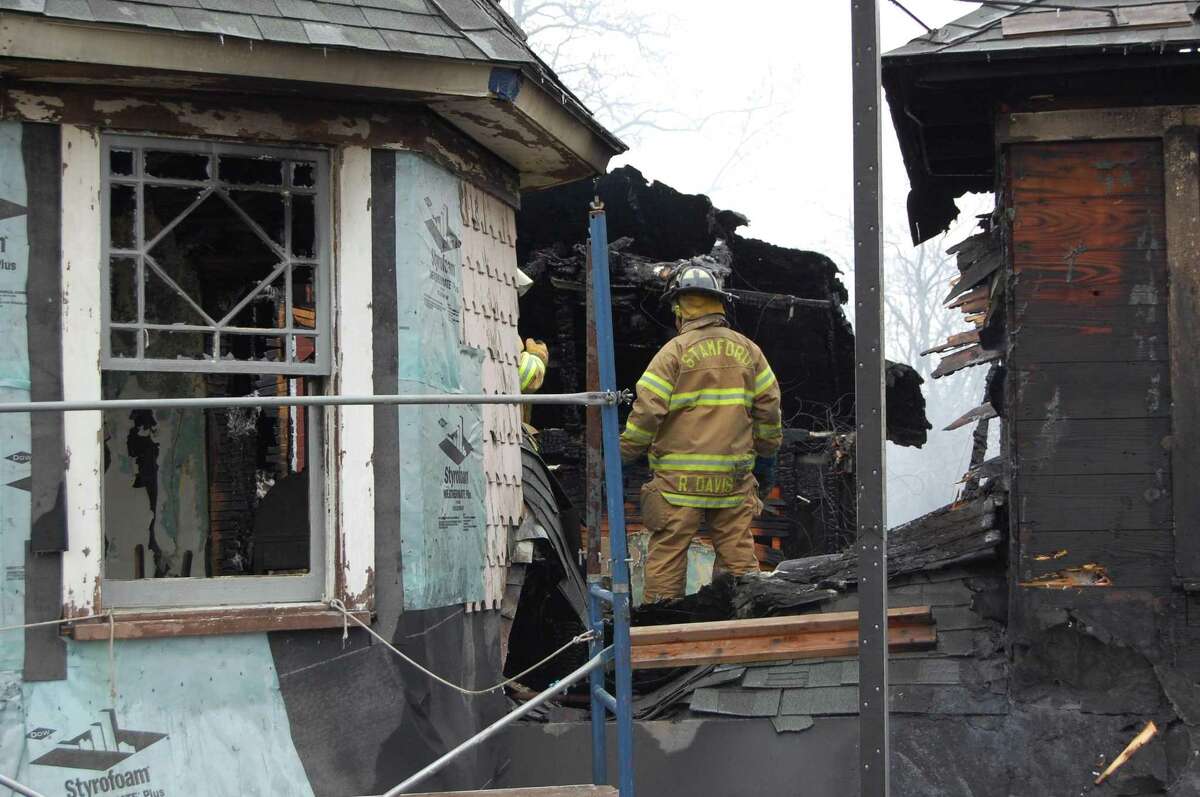Fire officials examine the scene after a fatal Christmas fire in 2011 at 2267 Shippan Ave.