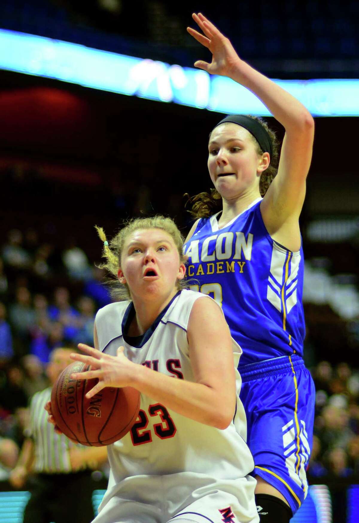 New Fairfield’s Kristen Teklits eyes the basket as Bacon Academy’s Jocelyn Luizzi comes in from behind to defend during their Class M championship game Saturday at the Mohegan Sun Arena.