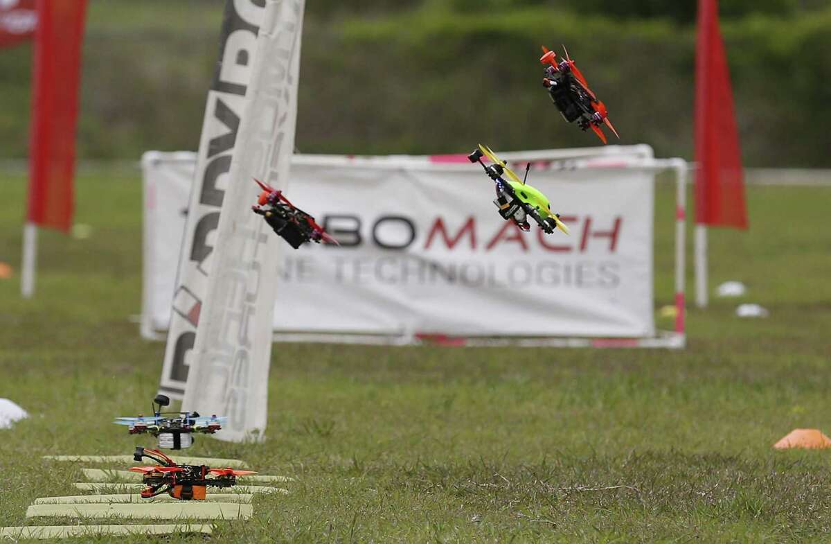 Drones are launched from the starting line during a practice session as drone racers from the area gather at Solms Park in New Braunfels, Texas for a competition qualifier on Saturday, Mar. 18, 2017. With their toolboxes, extra batteries and a cornucopia of drone parts, competitors practiced their best routes around a course of dips, dives and challenging obstacles before starting the qualifying rounds. With speeds reaching 70-80 miles per hour, racers rely on a good signal through their video FPV (first person view) googles and their cat-like reflexes to remotely fly the drones along the course. (Kin Man Hui/San Antonio Express-News)