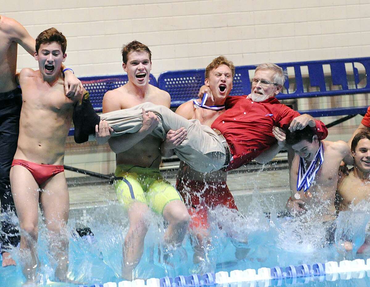 Greenwich swimmer Conrad Moss, center, screams as he and his teammates including Aedan Lewis, second from left, jump into the pool holding their coach, Terry Lowe, as they celebrated their victory in State Open Saturday at Yale University’s Kiphuth Pool in New Haven. Greenwich won its fifth straight State Open title by six points.
