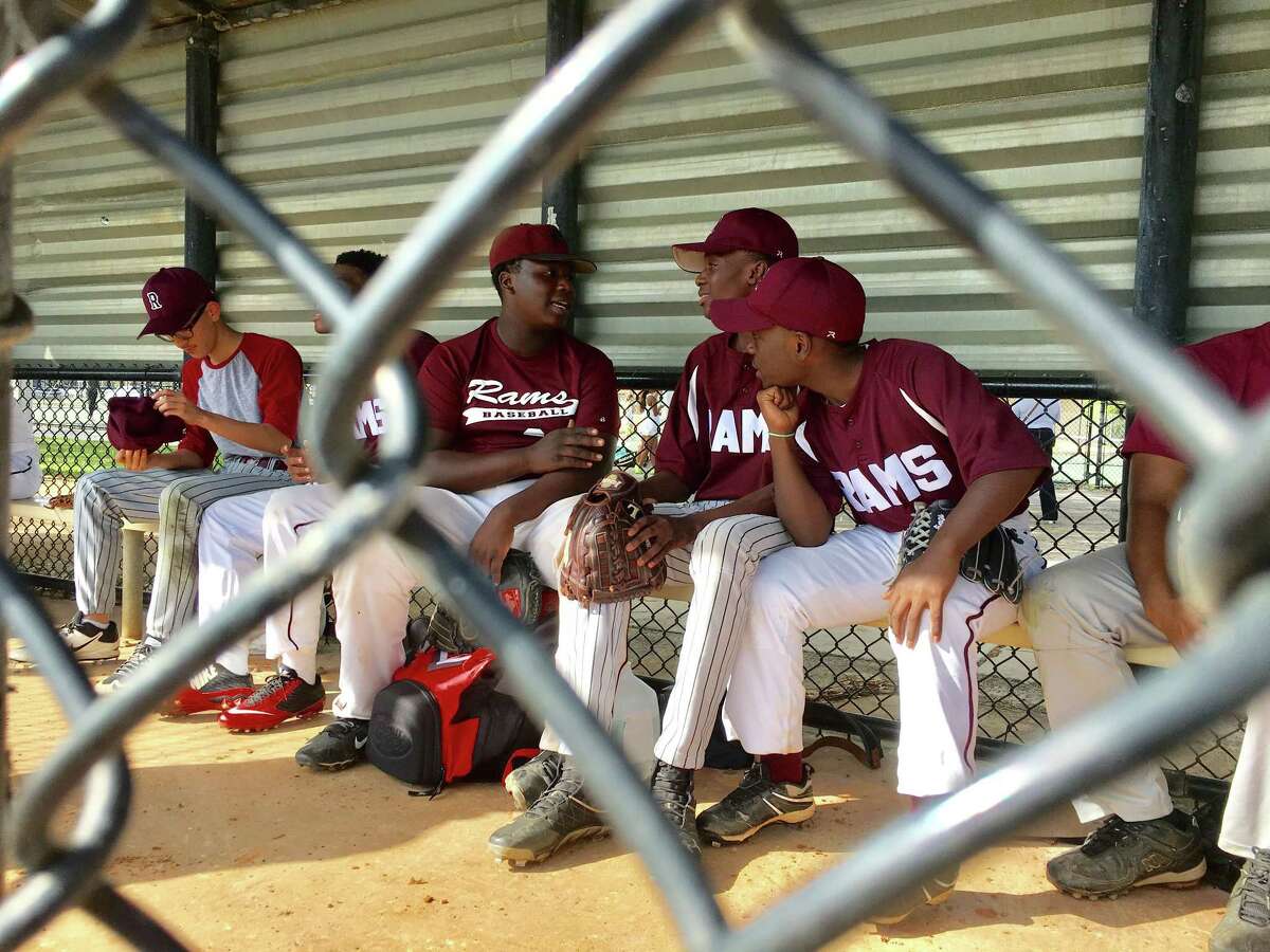 Ernest Nixon, center left, engages in some dugout chatter with his baseball teammates for Palm Beach Lakes Community High School, whose median household income is less than $33,000.