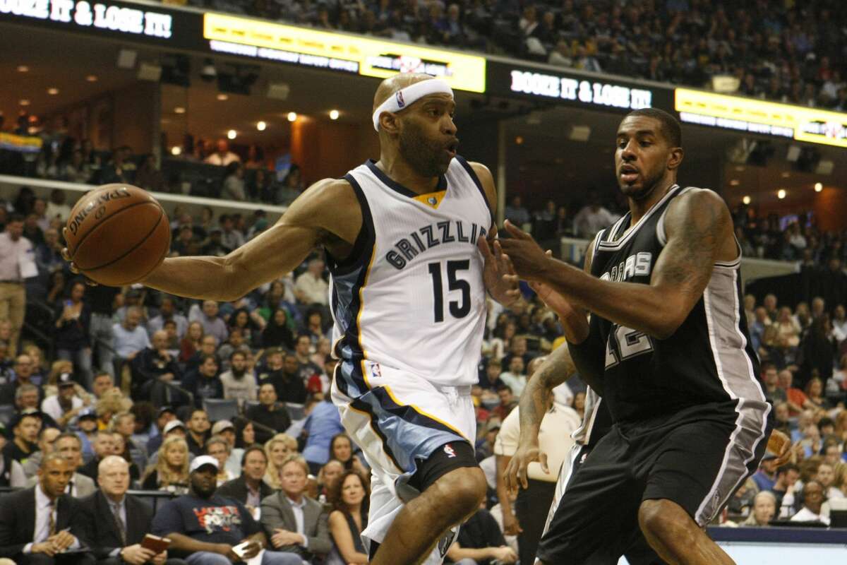 Memphis Grizzlies' Vince Carter (15) passes while being defended by San Antonio Spurs' LaMarcus Aldridge (12) in the first half of an NBA basketball game Saturday, March 18, 2017, in Memphis, Tenn. (AP Photo/Karen Pulfer Focht)