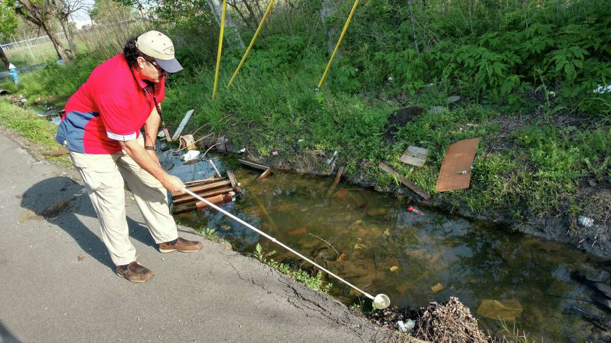 Salvador Rico, inspection supervisor with Harris County's ﻿Mosquito Control Division, examines standing water in a roadside ditch near SH-288 and Old Spanish Trail for larva, which can grow up to transmit disease. ﻿