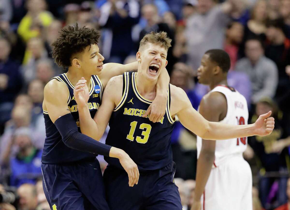 INDIANAPOLIS, IN - MARCH 19: Moritz Wagner #13 of the Michigan Wolverines celebrates a shot with D.J. Wilson #5 in the second half against the Louisville Cardinals during the second round of the 2017 NCAA Men's Basketball Tournament at the Bankers Life Fieldhouse on March 19, 2017 in Indianapolis, Indiana. Michigan Wolverines won 73-69. (Photo by Andy Lyons/Getty Images) *** BESTPIX ***