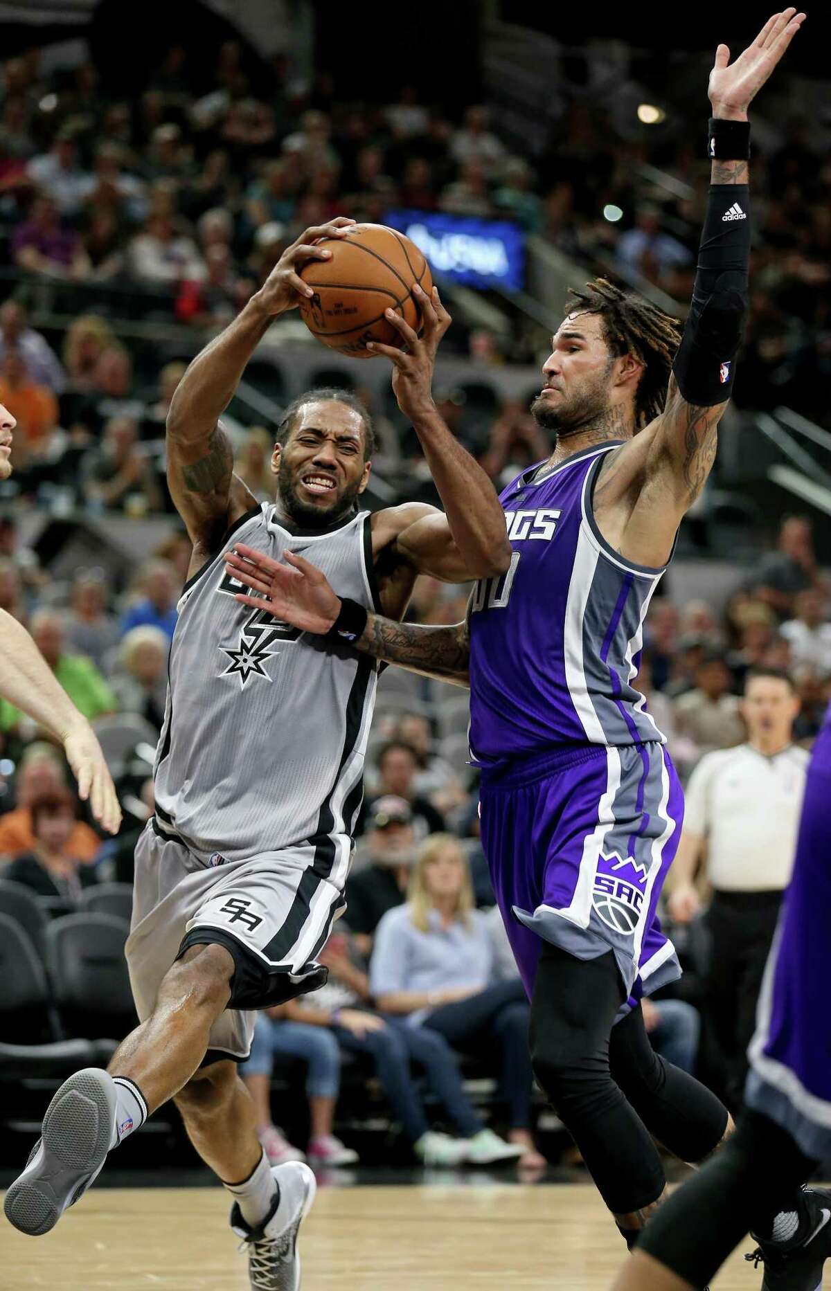 Spurs’ Kawhi Leonard drives around the Sacramento Kings’ Willie Cauley-Stein during second half action on March 19, 2017 at the AT&T Center.