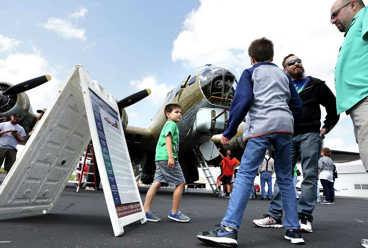 Eli Balderas, 6, left to right, his cousin Nathan Balderas, 10, Jim Balderas, and Jaime Balderas looks at the information on the B 17 G Flying Fortress at the Wings of Freedom Tour on display at Stinson Municipal Airport on Friday, March 17, 2017. The display, which is open to visits and flights, will go on thru Sunday, March 19th.
