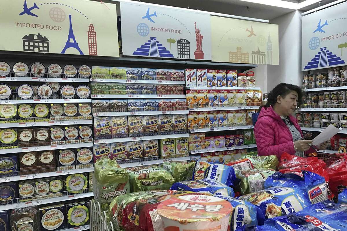 A vendor takes stock of imported food at a mall in Beijing, China. China plans to require intensive inspections of food imports — including such low-risk items as wine and chocolate. China’s trading partners say the move could disrupt billions of dollars in commerce.