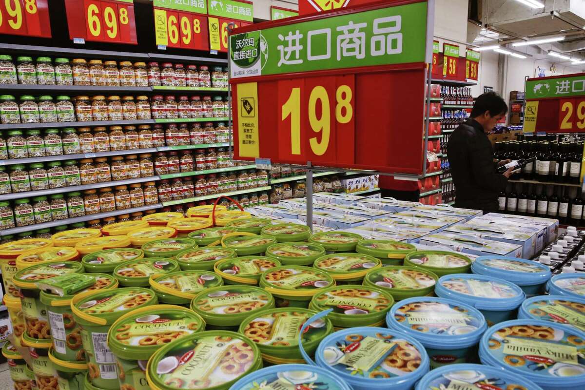 A man looks at imported wines on display for sale near the imported cookies and nuts at Walmart in Beijing. Under a Chinese rule, due to take effect as early as October, each consignment of food would require a certificate from a foreign inspector confirming it meets Chinese quality standards. Other countries require such inspections only for meat, dairy and other perishable items.