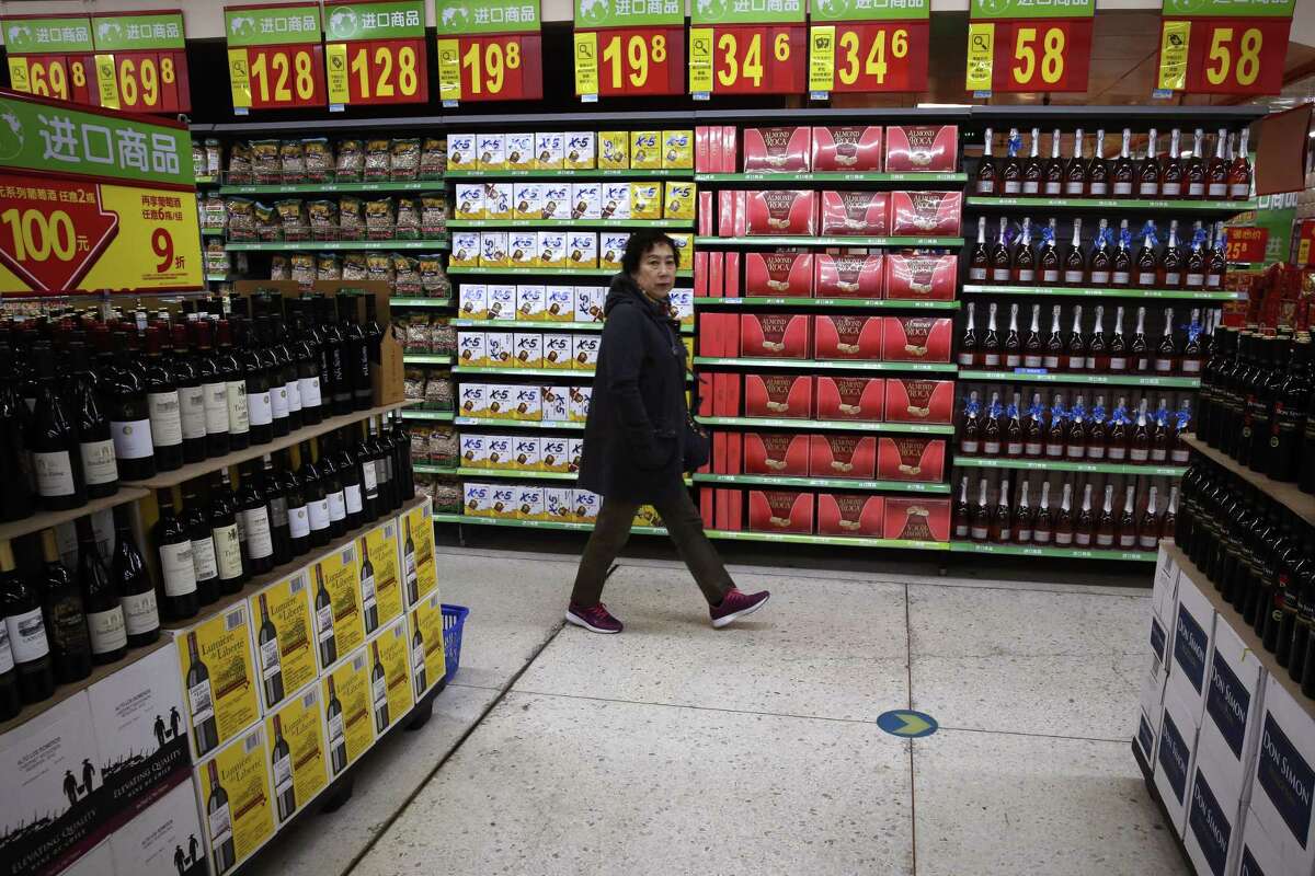 A woman walks by a section selling imported foods and beverages at Walmart in Beijing. A new Chinese rule requiring intensive inspections of food imports alarms suppliers that see China as a growing market for American fruit juice and snack foods, French wine, German chocolate, Italian pasta and Australian orange juice. Chinese regulators say closer scrutiny is needed as food imports increase.
